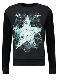 Black sweatshirt with a large turquoise star graphic, floral designs, and ribbed cuffs and hem for texture and definition.