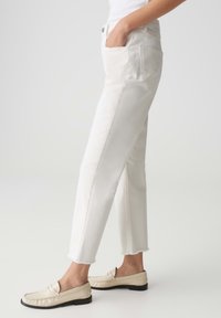 Witte katoenen jeans met een rechte pasvorm, voorzien van een rafelige zoom en zijzakken. In combinatie met beige instappers voor een complete look.