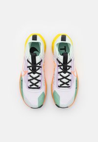 Ein Paar weiße, grüne und gelbe Laufschuhe mit schwarzen Schnürsenkeln und Gore-Tex-Logo, von oben auf einem weißen Hintergrund betrachtet.