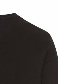 Sort striktrøje med en glat tekstur, rund halsudskæring og tætsiddende silhuet. Stoffet fremstår blødt og tæt.