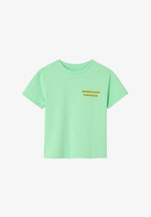 Mätovo zelené bavlnené tričko s krátkymi rukávmi a okrúhlym výstrihom s nápisom "AMERICAN VINTAGE" v tučnom žltom písme na prednej strane.