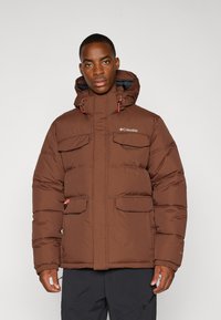 Braune Daunenjacke mit Kapuze, die mehrere Fronttaschen, orangefarbene Akzente und ein Logo auf der Brust hat; strukturierter Stoffdesign.