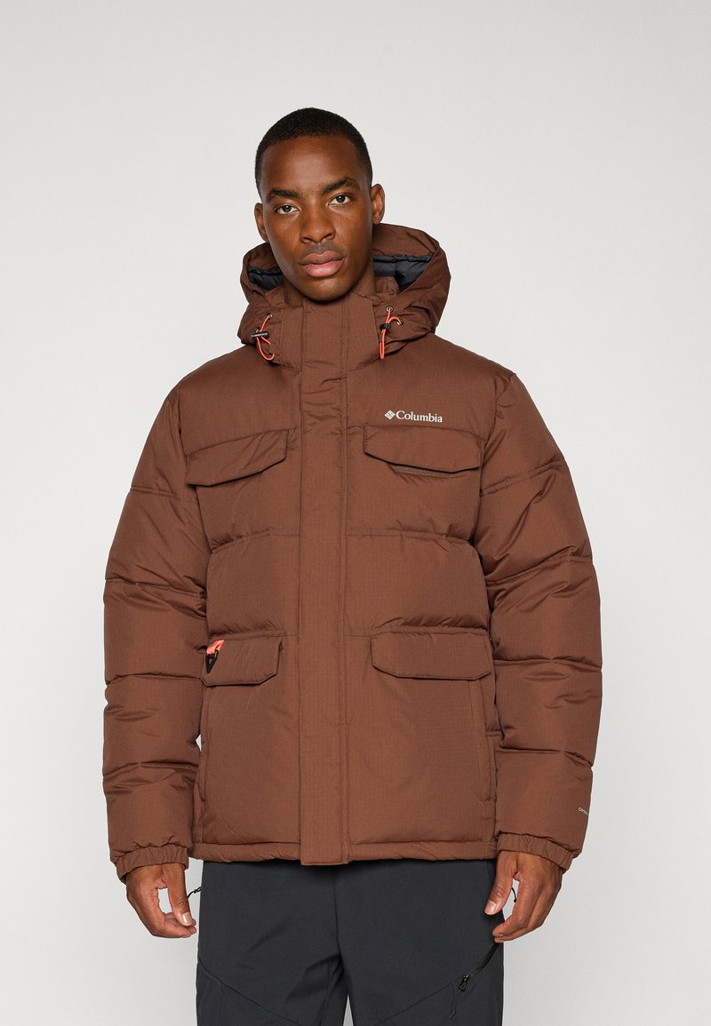 Braune Daunenjacke mit Kapuze, die mehrere Fronttaschen, orangefarbene Akzente und ein Logo auf der Brust hat; strukturierter Stoffdesign.