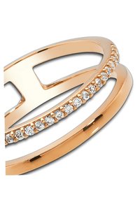 Bagues en or rose avec un anneau lisse et un anneau accentué orné de petites pierres claires disposées en rangée le long du bord supérieur.