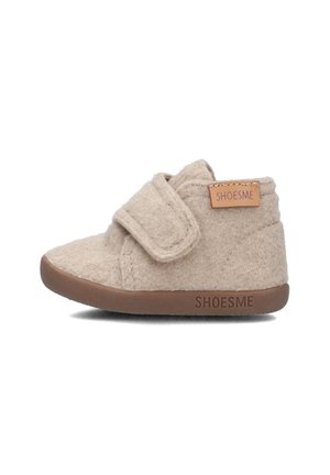 Beige vilten peuterschoen met een klittenbandsluiting en een bruine rubberen zolen. Bevat een gestikt patroon en een klein leren label met "SHOESME."