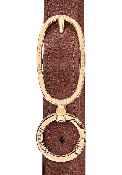 Brown leather strap featuring an oval gold-tone clasp with embossed "LONGCHAMP" logo and a round gold-tone ring detail. Texture visible.