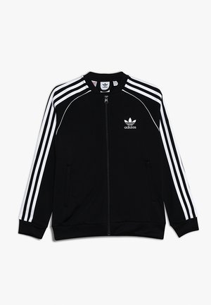 Czarna kurtka zapinana na zamek, wykonana z gładkiego materiału, z trzema białymi paskami biegnącymi wzdłuż rękawów oraz małym białym logo adidas na lewej piersi.