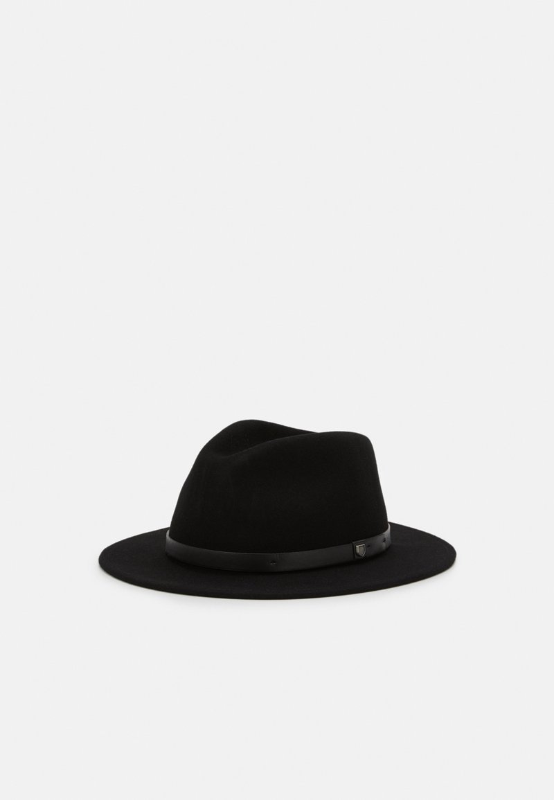 Chapeau fedora noir avec un large bord et une fine bande en cuir autour de la base de la calotte sur un fond clair uni.