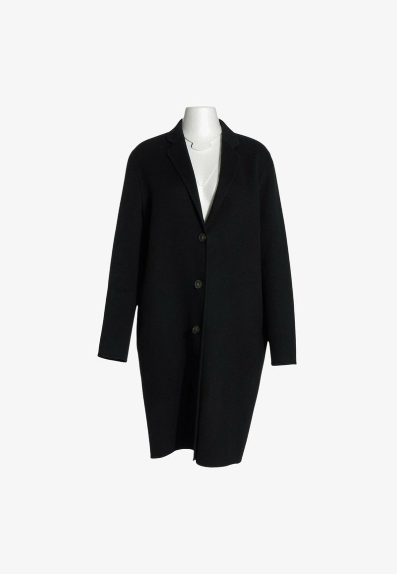 Long manteau noir en laine avec trois boutons sur un mannequin blanc sans tête sur fond blanc.