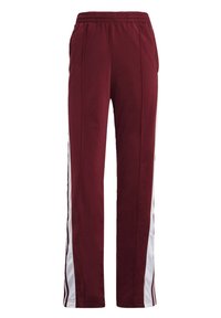 Pantalones deportivos burdeos con cintura elástica, dos bolsillos laterales y franjas laterales blancas que presentan una sutil textura en la tela.