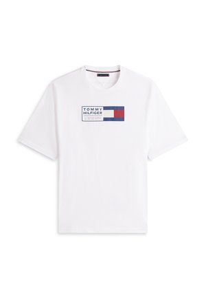 Weißes T-Shirt mit kurzen Ärmeln und Rundhalsausschnitt, mit einem rechteckigen Tommy Hilfiger Logo in Blau, Rot und Weiß, mittig auf der Brust platziert.