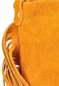 Orange ruskindstaske med blød tekstur, frynsedetaljer på siden og knaplukning øverst.