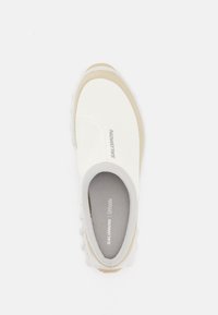 Balti slip-on batai su lygiu audiniu viršumi ir bežiniu akcentu; turi tekstūruotą pado ir pilką logotipą šone. Apskrito nosies dizainas.