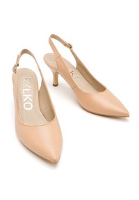 Nude skórzane czółenka na odkrytej pięcie z wydłużonym noskiem, z małym obcasem i regulowanym paskiem. Gładka tekstura i minimalistyczny design.