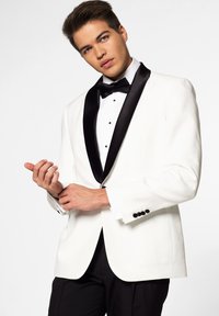 White tuxedo jacket with a black satin shawl collar, black buttons, and matching bow tie, worn over a white shirt and black trousers.