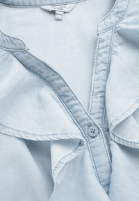 Lichtblauw denim blouse met een knoopsluiting bij de hals, zachte textuur en een gerimpelde kraagrand. Maatlabel: 38/40.