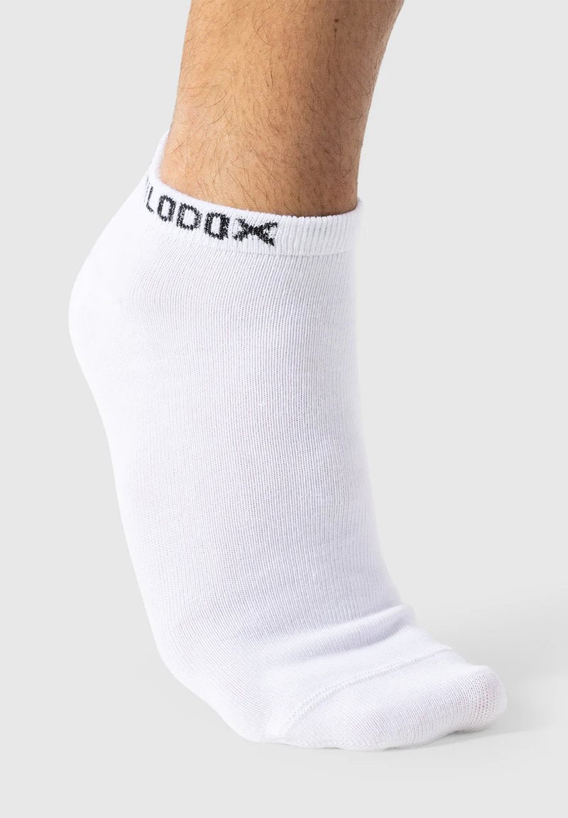 Hvide ankelstrømper lavet af glat stof. Har en ribbet manchet med mærkenavnet "LODAX" i sort. Pæn syning ved tåområdet.