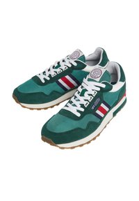 Une paire de baskets décontractées vertes avec des lacets blancs, des rayures latérales rouges, blanches et bleues, et des semelles en caoutchouc beiges.