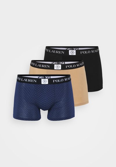 Trīs vīriešu bokseršortus: zili ar teksturētu rakstu, bēšas un melnas, katrs ar zīmola elastīgu jostasvietu.