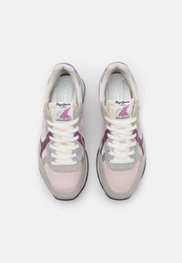 Zapatillas ligeras con una combinación de gamuza rosa, gris y morada. Cuentan con cordones blancos y un parche de logo vibrante en la lengüeta.