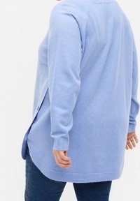 Lichtblauwe cardigan met lange mouwen, gemaakt van zachte, gestructureerde stof. Heeft een afgeronde zoom en knoopdetails aan de zijkant.