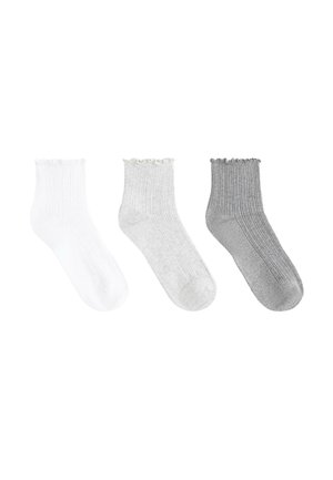 Three ribbed ankle socks in a row, colors white, light gray, and dark gray, each with a ruffled cuff at the top.