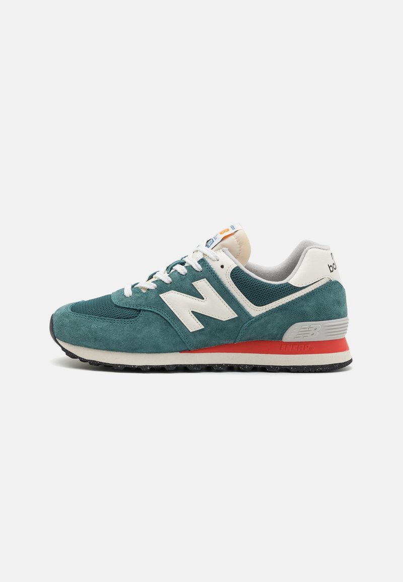 Baskets New Balance vertes et blanches avec textures en mesh et en daim, lacets blancs, accent rouge sur la semelle intermédiaire et semelle extérieure noire.