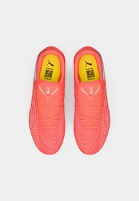 Scarpe sportive rosa brillante con tomaia testurizzata, caratterizzate da motivi puntinati tono su tono, suola in gomma e solette interne gialle a contrasto.