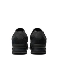 Black athletic shoes with suede and mesh materials, featuring a rounded toe, textured accents, and a ridged rubber sole. Logo visible on heel.