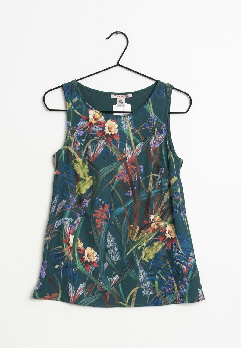 Haut sans manches vert foncé avec un motif floral et feuillage multicolore, encolure ronde, suspendu à un cintre noir sur fond blanc.