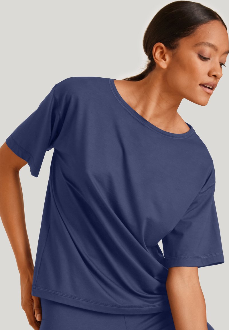 Marineblauwe t-shirt met korte mouwen, gemaakt van zachte, gladde stof. Heeft een ontspannen pasvorm en een ronde halslijn. Eenvoudig en veelzijdig ontwerp.