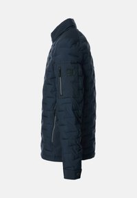 Marineblaue Steppjacke mit Stehkragen, seitlichen und Ärmeltaschen mit Reißverschluss sowie Druckknopfmanschetten, dargestellt von der linken Seite.