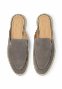 Un paio di mocassini grigi in suede, senza lacci, con solette in pelle beige e punte quadrate arrotondate, visti dall'alto su uno sfondo bianco.