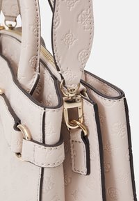 Beige læder handbag med præget mønster, guldbeslag og kontrasterende mørke kanter. Udstyret med dobbelt håndtag og lynlås lukning på toppen.