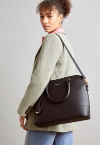 Sort læderhåndtaske med en struktureret design, gyldent hardware, to håndtag og en justerbar rem. Overfladen har en subtil tekstur.