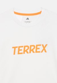 Λευκό βαμβακερό t-shirt με πορτοκαλί λογότυπο "TERREX" στο μπροστινό μέρος, με στρογγυλή λαιμόκοψη και αντίθετη πορτοκαλί επένδυση στο εσωτερικό του γιακά.