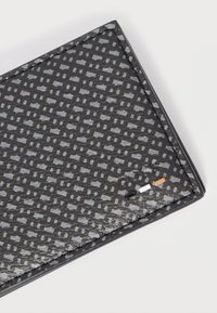 Čierna textúrovaná peňaženka s geometrickým vzorom, lesklým povrchom a kontrastným prešívaním. Na okraji malé farebné akcenty.