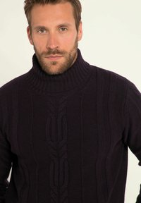 Dunkelpurpurner, gestrickter Rollkragenpullover mit strukturierten Kabelmustern und gerippten Akzenten, der eine gemütliche und strukturierte Optik bietet.