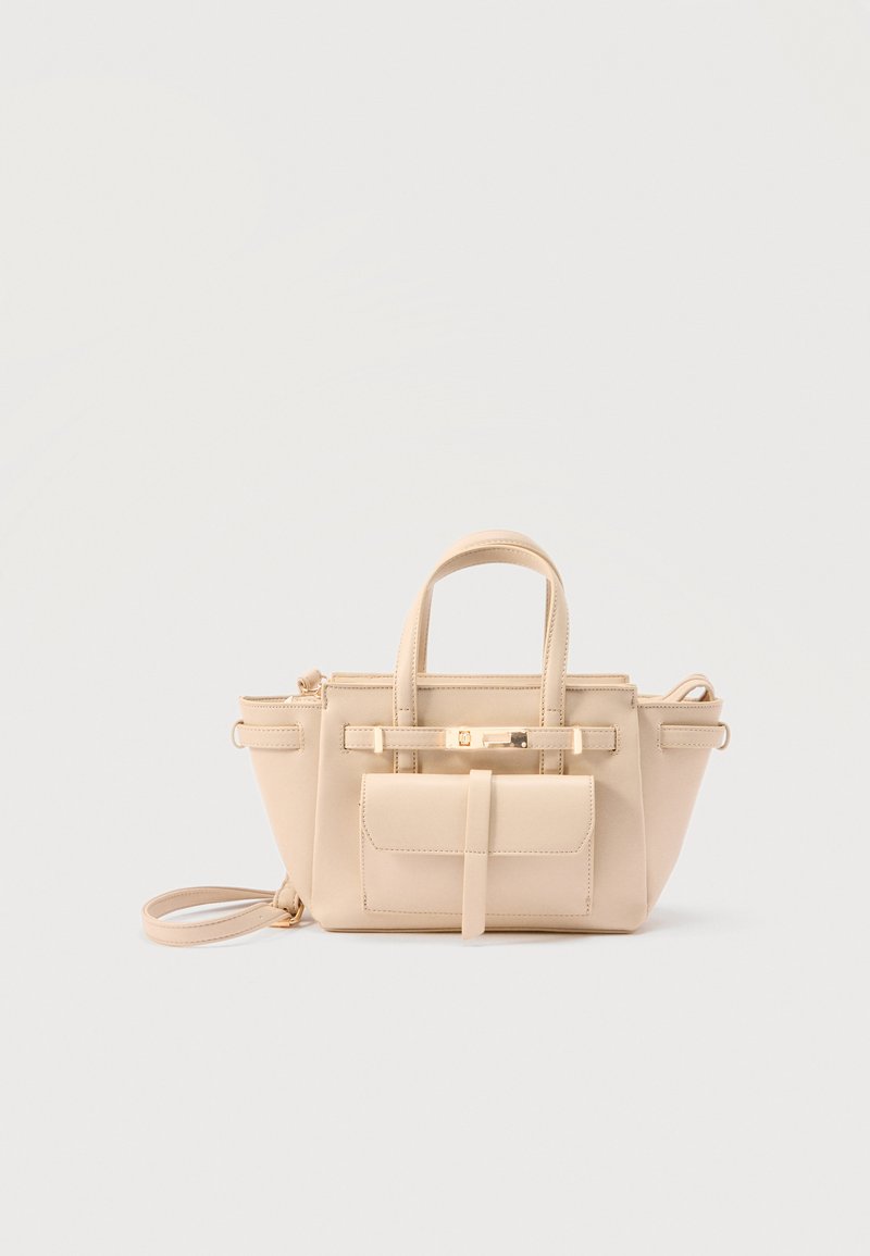 Sac à main en cuir beige avec double poignées, poche à rabat sur le devant, fermoir doré et bandoulière amovible sur un fond uni.