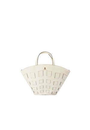 Borsa bianca a trapezio con ritagli quadrati e doppi manici, con un piccolo dettaglio teschio dorato vicino alla parte superiore centrale.
