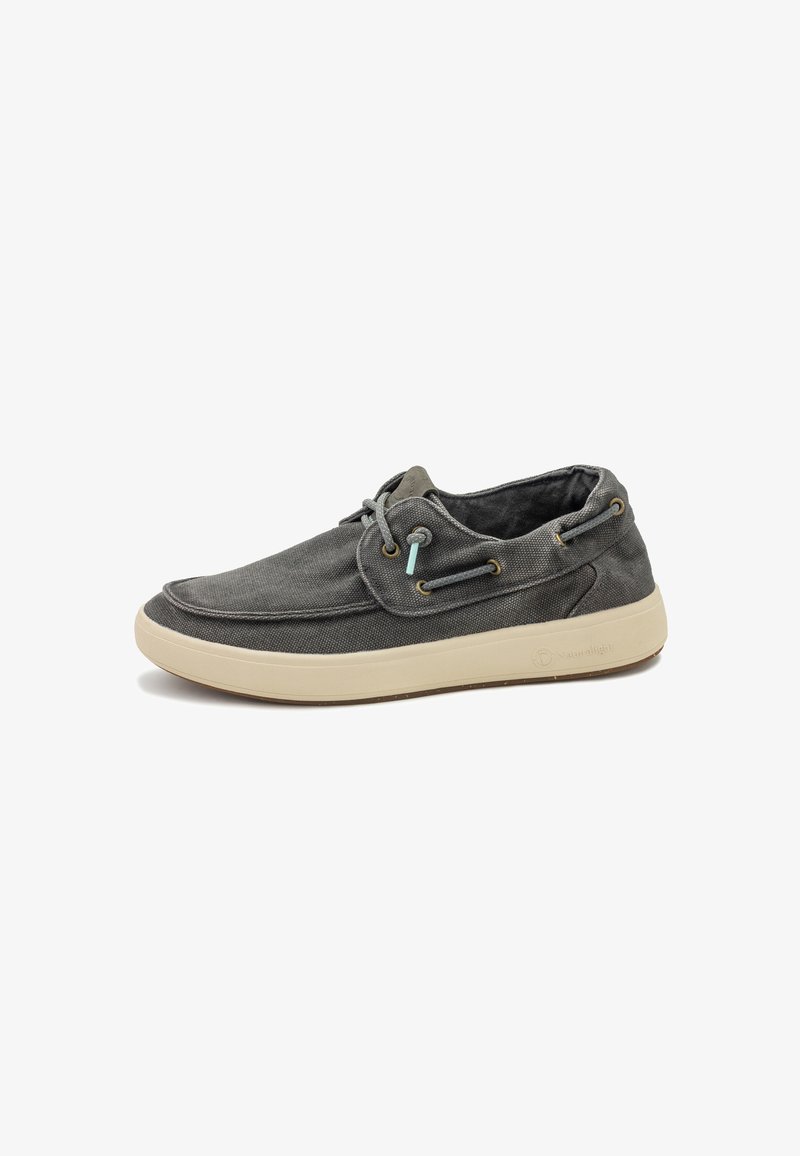 Chaussure décontractée grise en toile basse avec semelle en caoutchouc beige, à lacets sur le devant et œillets ronds en métal, sur fond blanc.