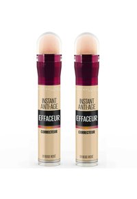 Deux correcteurs Maybelline Instant Anti-Age dans un emballage cylindrique, d'une couleur rose beige clair, avec un applicateur arrondi et une étiquette noire frappante.