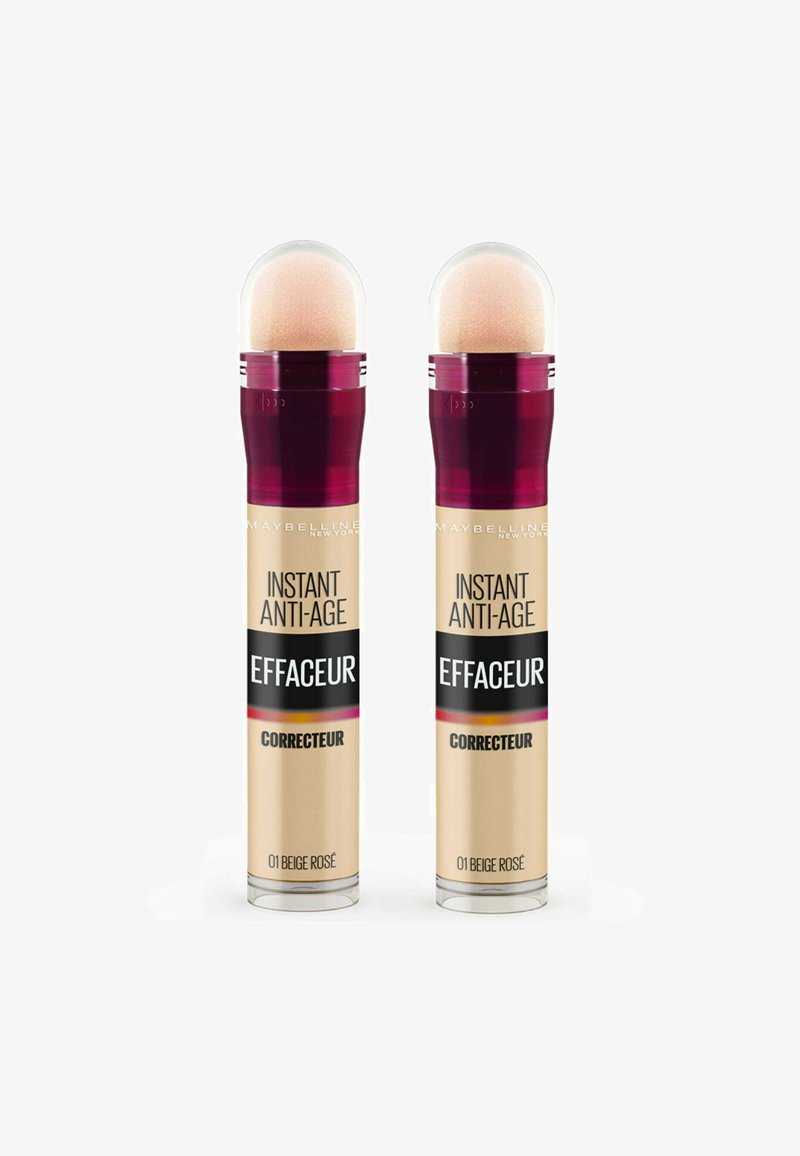 Deux correcteurs Maybelline Instant Anti-Age dans un emballage cylindrique, d'une couleur rose beige clair, avec un applicateur arrondi et une étiquette noire frappante.