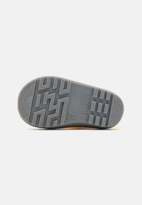 Pelēkā gumijas apakšzole ar teksturētu saķeres rakstu, apzīmēta ar izmēru EUR 18, UK 2, US 3 un zīmola nosaukumu "Playshoes."