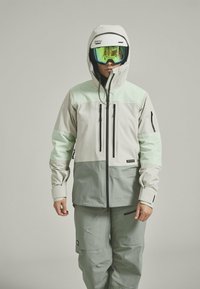 Ski jacket with a light gray and mint green color scheme, featuring a zippered front, multiple pockets, and a helmet-compatible hood.