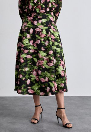 Fustă florală neagră, cu un model de frunze roz și verzi. Siluetă în formă de A, dintr-un material texturat, cu un tiv care coboară sub genunchi.