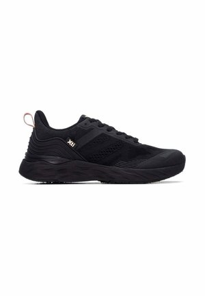Zapatilla deportiva negra con suela texturizada, parte superior de malla, cordones y pequeña etiqueta con logo en el lateral, mostrada desde la vista lateral exterior.
