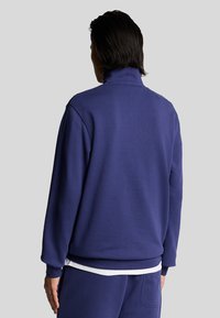 Mörkblå högkragad sweatshirt, tillverkad av mjuk bomullsblandning, med ribbade ärmslut och nederkant, med en slät textur och avslappnad passform.