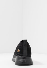 Sneaker nera con tomaia in maglia e dettagli testurizzati. Suola in gomma con un logo discreto sul tallone e una linguetta integrata.