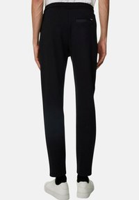 Svarta joggerbyxor i mjukt tyg, med en tapered design, elastisk midja och en bakficka med en minimal detalj.